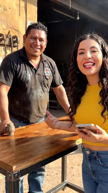 Herrero entregando una mesa industrial a una clienta satisfecha